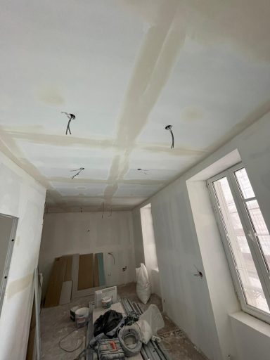 Techo en proceso de reforma con restos de obra, paredes desnudas y escombros en el suelo.