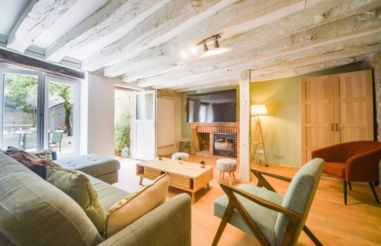 Salón luminoso y moderno con sofás, mesa de centro e iluminación cálida.