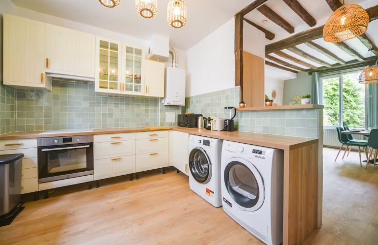 Cocina moderna con electrodomésticos, encimera de madera y espacio luminoso.