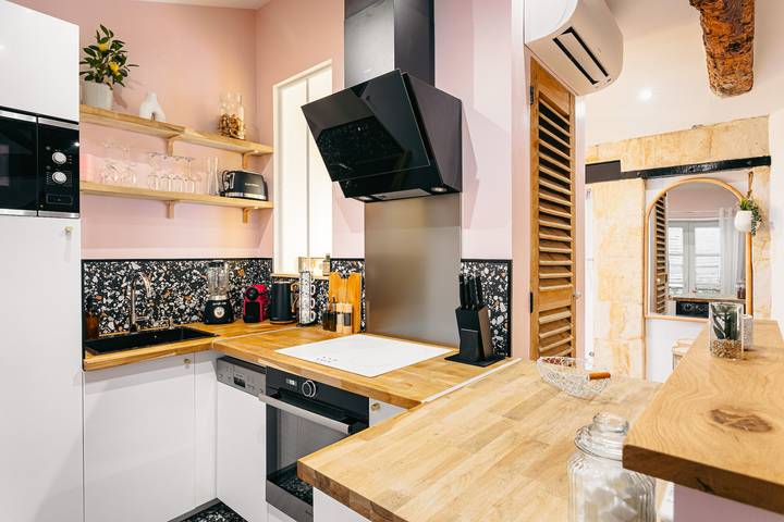 Cuisine moderne avec des étagères en bois, plan de travail en bois et électroménagers intégrés.